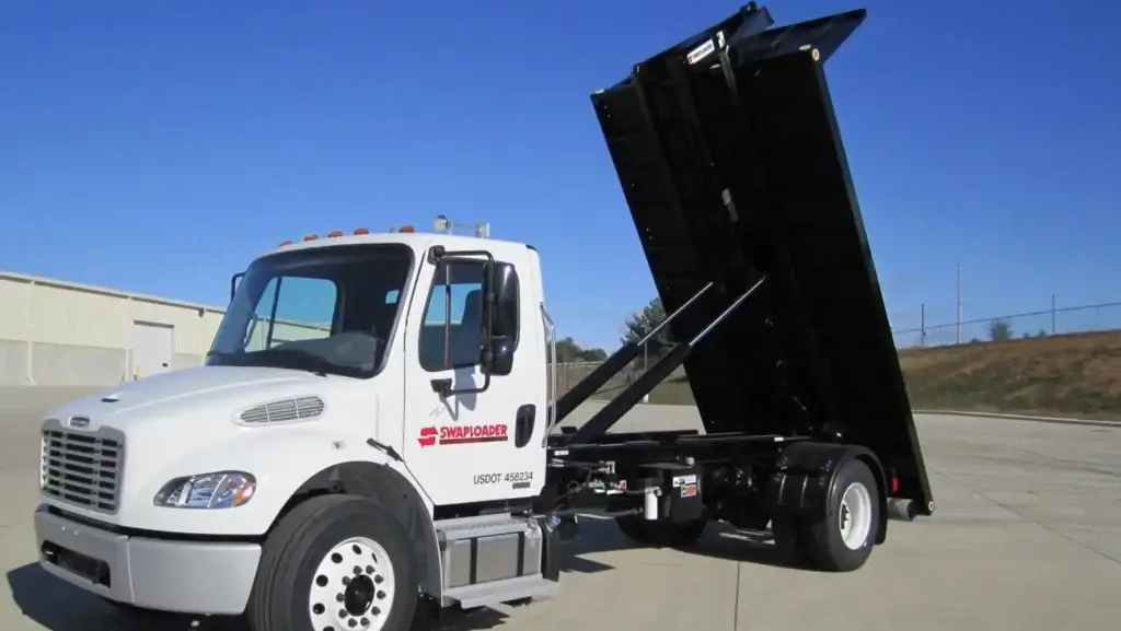 White swaploader truck with the hoist lifted in the air.