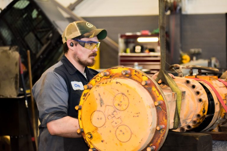 Equipment service tech working on large piece of equipment