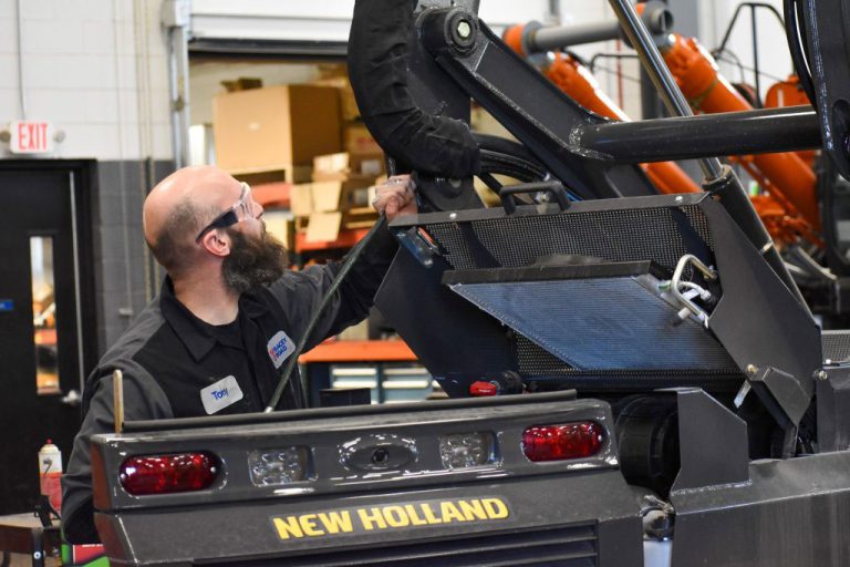Equipment tech working on new holland